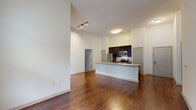 Located at 322 Baldwin Road in Odenton, MD, this 2-bedroom, 2-bathroom residence offers a well-designed single-level layout with notable architectural details throughout. The open-concept living and kitchen area is anchored by soaring ceilings that amplify the sense of space, while rich hardwood flooring runs seamlessly through the main living areas. The kitchen features a large granite-topped island with an integrated sink, dark espresso cabinetry, a tile backsplash, and a full suite of stainless steel appliances including a refrigerator, microwave, and range. A pantry provides additional storage convenience. Both bedrooms are carpeted and benefit from tall ceilings and generous natural light through large double windows with views of surrounding greenery. The primary bedroom is a well-proportioned retreat with its own closet access. Three closets in total offer ample storage throughout the unit. Both bathrooms are finished consistently with granite-topped dark vanities, beige tile flooring, and full tub-shower combinations with tile surrounds and curved curtain rods. The overall aesthetic is clean and modern, with a neutral palette that lends a bright, welcoming ambiance throughout the home.
