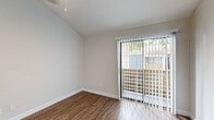 This 1-bedroom, 1-bathroom unit offers a thoughtfully designed layout that maximizes its compact footprint across a single floor. Wood-style flooring runs throughout, providing a warm, cohesive aesthetic in every room.

The open-plan kitchen and living area serves as the heart of the space. The kitchen is well-equipped with stainless steel appliances — including a refrigerator, range, microwave, and dishwasher — complemented by white shaker cabinetry, a classic white subway tile backsplash, and granite countertops. A stainless steel sink with a window view adds both functionality and natural light. The living area benefits from soaring vaulted ceilings that lend a sense of openness, with a ceiling fan overhead and a sliding glass door fitted with vertical blinds that opens to an outdoor area with views of surrounding greenery.

The bedroom is a comfortable, well-proportioned space featuring a standard window with horizontal blinds that brings in natural light, and access to a dedicated closet for storage.

The bathroom is clean and functional, featuring a white vessel sink set atop a granite vanity, a mirrored medicine cabinet, and a full tub-shower combination with white tile surround.

Neutral wall tones and consistent flooring throughout give the unit a bright, move-in-ready ambiance.