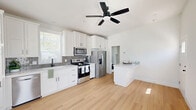 Located at 53 N Conejo School Rd in Thousand Oaks, CA, this efficiently designed 1-bedroom, 1-bathroom residence offers a clean, modern aesthetic with thoughtful finishes throughout. The open-concept kitchen and living area forms the heart of the home, showcasing crisp white shaker cabinetry, a gray subway tile backsplash, and a full suite of stainless steel appliances including a French door refrigerator, electric range, microwave, and dishwasher. A white peninsula provides additional counter space and casual seating. A sleek ceiling fan overhead and a large window allow natural light to fill the space, enhancing the airy, bright atmosphere. Light-toned hardwood-style flooring runs continuously throughout, lending warmth and visual cohesion to every room. The bedroom is a serene, well-lit retreat with dual corner windows fitted with blinds, allowing flexible natural light control. It features a generous closet and direct access to an in-unit washer and dryer. The bathroom is finished in a clean, contemporary style with a white vanity, a tub-shower combination enclosed by a black-framed sliding glass door, and a high window for natural ventilation. The entryway is bright and welcoming, completed by a classic six-panel door. Every detail reflects a fresh, move-in-ready condition.
