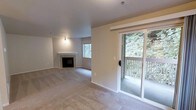 This single-floor, 2-bedroom, 1-bathroom residence offers a well-organized layout designed for comfortable everyday living. The main living area is carpeted and anchored by a classic fireplace with a clean white mantle and tile surround, providing a welcoming focal point. A window alongside the fireplace allows natural light to filter into the space, while neutral-toned walls and light-colored carpet create a bright, understated atmosphere throughout.

A sliding glass door opens directly to a private balcony, offering an appealing transition between indoor and outdoor living. The balcony overlooks a dense, lush tree canopy, providing a serene and natural backdrop that enhances the overall ambiance of the unit.

The layout is efficient and functional, making practical use of the available space across both bedrooms and the shared bathroom. The neutral finishes and soft carpeting contribute to a calm, livable environment. Overall, this residence combines key interior features — including the fireplace and natural light — with appealing outdoor greenery views, making it a comfortable and inviting single-level living space.