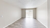 Located at 2320 Coleman Rd in Anniston, Alabama, this single-floor, 2-bedroom, 2-bathroom residence offers a practical and well-organized layout. The living room is a bright, open space featuring light-toned vinyl plank flooring and a sliding glass door fitted with vertical blinds that allows natural light to pour in while providing outdoor views. Adjacent to the living area is a dedicated dining space that connects smoothly to the galley-style kitchen. The kitchen is efficiently designed with white cabinetry, white laminate countertops, a double-basin sink, a dishwasher, a full-size refrigerator, and a coil-burner electric range, all complemented by the same light vinyl plank flooring. The two bedrooms offer a comfortable retreat, each featuring neutral carpet flooring and textured ceilings. The primary bedroom is a generously sized room, while the secondary bedroom includes a window that brings in natural light and outdoor views. Both bathrooms are finished with vinyl plank flooring and include tub-shower combinations. A closet provides additional storage, and a hallway connects the private areas of the home. Throughout the unit, a consistent neutral color palette, textured ceilings, and clean white trim contribute to a cohesive and tidy overall ambiance.