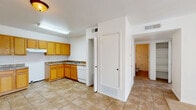 Located at 2140 N Zaragoza Rd in El Paso, TX, this single-story, two-bedroom, one-bathroom home offers a practical and well-organized layout. The kitchen is a standout feature, equipped with warm honey-toned wood cabinetry, laminate countertops, a double-basin sink, a dishwasher, and a full-size refrigerator. The L-shaped counter configuration maximizes workspace, while durable tile flooring extends throughout the kitchen and main living areas, making for easy maintenance. A dedicated pantry closet provides additional storage. Both bedrooms are carpeted and feature sliding-door closets with built-in shelving and hanging rods, offering ample storage space. Natural light filters into the bedrooms through windows with views of surrounding greenery. The bathroom includes a full tub-shower combo with white subway tile surround, providing a clean, classic look. A hallway connects the main living areas to the bedrooms and bathroom, ensuring a logical and efficient flow throughout the home. The overall design is straightforward and functional, with a neutral color palette that creates a bright, open atmosphere throughout the space.