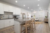 This well-appointed one-bedroom, one-bathroom unit in Chubbuck, Idaho offers a thoughtfully designed single-floor layout that maximizes every square foot. Light wood-style flooring flows throughout, unifying the space with a clean, contemporary aesthetic.

The open-concept kitchen and living area serves as the heart of the home. The kitchen is outfitted with crisp white shaker cabinetry, grey quartz countertops, a subway tile backsplash, and a full suite of stainless steel appliances including a refrigerator, range, microwave, and dishwasher. A central island with bar seating provides additional prep space and casual dining functionality.

The adjoining living area is bright and airy, with large windows dressed in sheer curtains that invite abundant natural light and offer pleasant outdoor views. Recessed lighting throughout adds to the well-lit ambiance.

The bedroom is a comfortable retreat, featuring a generously sized window with views of the surrounding greenery, providing a calm and restful atmosphere. A closet provides dedicated storage, keeping the space organized and functional.

The bathroom is cleanly finished with white cabinetry, a grey countertop vanity, wood-style flooring, and a full tub/shower combination. A hallway connects the living areas to the private spaces, completing the efficient and practical floor plan.