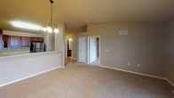 Located at 4301 W 57th St in Sioux Falls, South Dakota, this single-floor residence offers a well-designed layout with a blend of hardwood-style flooring and plush carpeting throughout its living spaces. The living room serves as a central gathering area, highlighted by a corner fireplace with a rich wood mantle and a large window that brings in natural light and views of the surrounding neighborhood. Adjacent to the living area, the dining space features vaulted ceilings and an elegant pendant chandelier, creating an open and airy atmosphere. The kitchen is thoughtfully designed with warm wood cabinetry, light countertops, and stainless steel appliances including a range, over-the-range microwave, and refrigerator, all complemented by hardwood-style flooring. A breakfast bar connects the kitchen to the dining and living areas, enhancing the open-concept feel. The carpeted bedrooms are generously sized, with vaulted ceilings in the primary bedroom, ceiling fan lighting, and windows offering outdoor views. A hallway leads to the bathroom, which includes a vanity with a single basin sink, warm wood cabinetry, and a large mirror. The unit also features ample closet and storage space, with a clean, neutral color palette maintained throughout.