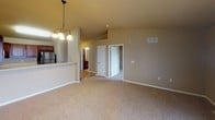 Located at 4301 W 57th St in Sioux Falls, South Dakota, this single-floor residence offers a well-designed layout with a blend of hardwood-style flooring and plush carpeting throughout its living spaces. The living room serves as a central gathering area, highlighted by a corner fireplace with a rich wood mantle and a large window that brings in natural light and views of the surrounding neighborhood. Adjacent to the living area, the dining space features vaulted ceilings and an elegant pendant chandelier, creating an open and airy atmosphere. The kitchen is thoughtfully designed with warm wood cabinetry, light countertops, and stainless steel appliances including a range, over-the-range microwave, and refrigerator, all complemented by hardwood-style flooring. A breakfast bar connects the kitchen to the dining and living areas, enhancing the open-concept feel. The carpeted bedrooms are generously sized, with vaulted ceilings in the primary bedroom, ceiling fan lighting, and windows offering outdoor views. A hallway leads to the bathroom, which includes a vanity with a single basin sink, warm wood cabinetry, and a large mirror. The unit also features ample closet and storage space, with a clean, neutral color palette maintained throughout.