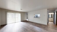 Located at 2501 Riverfront Dr in Little Rock, Arkansas, this single-floor residence offers a practical and well-appointed layout with four bedrooms and three bathrooms. The open living room features rich wood-look flooring, neutral walls, and a sliding glass door with vertical blinds that allows generous natural light to flow in. A pass-through window connects the living area directly to the kitchen, enhancing the open feel between spaces. The kitchen is efficiently designed with white shaker-style cabinetry, granite-look countertops, stainless steel appliances including a refrigerator and dishwasher, and wood-look flooring that ties the space together. The bedrooms are carpeted for comfort, each equipped with a ceiling fan and light fixture. The primary bedroom receives ample natural light through a large window and features a closet with mirrored sliding doors. Additional bedrooms include built-in closets and ceiling fans. The three bathrooms are clean and functional, each featuring a tub-shower combination with chrome fixtures, wood-look flooring, and granite-look vanity countertops. Throughout, the home maintains a consistent, neutral color palette that creates a calm and cohesive ambiance.