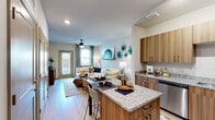Located at Chatham Center Drive in Savannah, Georgia, this one-bedroom, one-bathroom unit offers a thoughtfully designed layout that maximizes functionality across its single floor. The open-concept kitchen and living area serves as the heart of the space, where light wood-tone cabinetry, granite countertops, and stainless steel appliances define a contemporary kitchen equipped with a built-in island that doubles as a casual dining area with bar seating. The kitchen transitions seamlessly into the living room, which is brightened by multiple windows and a glass exterior door that floods the area with natural light. Light hardwood-style flooring runs throughout the main living area, enhancing the open, airy feel.

The bedroom is a comfortable retreat featuring plush carpet, a ceiling fan, and windows that invite natural light and outdoor views. An adjacent walk-in closet provides ample wire-rack shelving and hanging space for organized storage. The bathroom features granite countertops atop warm wood cabinetry, hardwood-style flooring, and a shower with a curtained enclosure. The overall ambiance of the unit is modern and welcoming, with clean lines and contemporary finishes throughout.