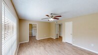 Located at 11850 Wentling Ave, Unit K9 in Baton Rouge, Louisiana, this two-bedroom, two-bathroom residence offers a practical and well-organized single-floor layout. The living room serves as the central gathering space, featuring warm wood-look laminate flooring, a ceiling fan with light fixture, and a large window that allows natural light to fill the room. Neutral beige walls and white trim carry throughout, creating a consistent and clean aesthetic.

The kitchen is equipped with white cabinetry, a double sink, laminate countertops, and white appliances including a refrigerator and range. Wood-look flooring continues here, complementing the bright, functional design.

The primary bedroom offers a comfortable amount of space with plush carpeting, a ceiling fan, a window with outdoor views, and a closet with sliding doors providing ample storage. The second bedroom is similarly appointed with carpet flooring and a ceiling fan, making it well-suited as a guest room or home office.

Both bathrooms are functional and tidy. One features a full tub-shower combination with a white surround, while the second includes a vanity with a single sink and a large mirror. Both feature wood-look flooring and warm neutral wall tones. A hallway connects the bedrooms and bathrooms, completing this efficiently designed home.