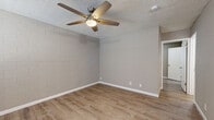 Located at 740 W University Dr in Tempe, Arizona, this one-bedroom, one-bathroom unit offers a practical and efficiently designed single-floor layout. The interior features light wood-look luxury vinyl flooring throughout, lending a clean and cohesive aesthetic to every room.

The living area is bright and open, with neutral gray-toned walls, white baseboards, and windows fitted with white horizontal blinds that allow for natural light control. A paneled entry door provides direct access to the space. Ceiling fans with integrated lighting are present in multiple rooms, providing both comfort and illumination suited to the Arizona climate.

A distinctive architectural element throughout the unit is the painted cinder block wall construction, which adds texture and a subtle industrial character to the living and bedroom areas. The textured ceiling further complements this utilitarian design style.

The bedroom is a comfortable size, with its own ceiling fan and window with blinds, offering natural light and ventilation. A dedicated closet provides practical storage.

The bathroom is clean and functional, featuring a white vanity with storage cabinetry, a toilet, and a full-size tub and shower combo with a white surround. The same wood-look flooring carries through into this space, maintaining visual consistency.

Overall, this unit presents a straightforward, well-maintained living space ideal for those seeking a no-frills, functional home in the heart of Tempe near Arizona State University.