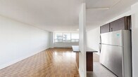 Located on the 16th floor at 155 Wellesley St E in the heart of Toronto, this one-bedroom, one-bathroom unit offers a well-organized layout across a single floor. The open-concept living and dining area is bright and airy, featuring warm parquet wood flooring in a classic basket-weave pattern and floor-to-ceiling windows that flood the space with natural light. These expansive windows frame sweeping views of Toronto's skyline, neighbouring green canopy, and surrounding residential neighbourhoods, creating a strong sense of elevation and openness.

The kitchen is thoughtfully designed with rich dark-stained cabinetry, stainless steel appliances including a full-size refrigerator, electric range, and built-in microwave, complemented by a white subway tile backsplash and a breakfast bar peninsula that connects seamlessly to the living area. Tile flooring runs throughout the kitchen for easy maintenance.

The bedroom is a comfortable, well-proportioned room with parquet flooring, a large closet with bi-fold doors, and a window offering city views. The bathroom features a full soaker tub with an overhead shower, finished with clean, large-format beige wall tiles and chrome fixtures. A hallway connects all rooms efficiently, completing this practical and attractive urban residence.