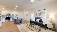 Located at 1030 Clearwater Largo Rd N in Largo, Florida, this single-floor residence offers a thoughtfully designed open-concept layout that seamlessly connects the kitchen, dining, and living areas. The kitchen is outfitted with crisp white shaker cabinetry, dark stone countertops, a classic subway tile backsplash, and a full suite of stainless steel appliances, including a refrigerator, range, microwave, and dishwasher. Abundant cabinet storage, including tall pantry-style units, ensures excellent organization. Light wood-look flooring runs throughout the main living areas, contributing to a bright and cohesive aesthetic. The dining area accommodates a round table with comfortable seating, positioned conveniently between the kitchen and the open living room. The living room features a ceiling fan, recessed lighting, and a large window that invites natural light. The bedroom features plush carpeting, multiple windows with outdoor views, and ample space for furnishings. The bathroom is finished with large-format tile on both the floors and tub surround, paired with a full soaking tub and shower combination. Throughout the residence, a neutral color palette, clean lines, and contemporary finishes create a modern yet welcoming atmosphere.