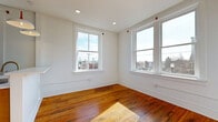 Located at 901 S 5th St in Lynchburg, Virginia, this 2-bedroom, 1-bathroom unit offers a well-organized single-floor layout that makes efficient use of its cozy footprint. Rich, warm-toned hardwood floors run throughout the living spaces, adding character and continuity across each room.

The living room provides a bright, open area bathed in natural light, while the kitchen is equipped with stainless steel appliances — including a refrigerator, electric range, and over-the-range microwave — complemented by light wood cabinetry, white countertops, and hardwood flooring. A large window in the kitchen frames views of the surrounding Lynchburg streetscape.

Both bedrooms feature gleaming hardwood floors and multiple windows that invite generous natural light and offer outward views of the neighborhood's brick architecture. The primary bedroom is a comfortable, well-proportioned space with recessed lighting and convenient closet access.

The bathroom is a standout, finished with classic penny tile flooring, a light wood vanity, a round mirror, and elegant brushed gold fixtures throughout — including faucet, towel ring, and shower hardware — paired with a full tub-shower combination. Additional utility and laundry areas round out the functional layout of this thoughtfully updated unit.