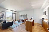 This thoughtfully designed one-bedroom, two-bathroom residence in Washington, DC offers a clean, modern aesthetic throughout its well-organized single-floor layout. Light hardwood flooring flows seamlessly from the welcoming entrance hallway into the open-concept living and dining areas, creating a bright and cohesive feel. Large floor-to-ceiling windows bathe the living room in natural light and frame outdoor views, while recessed and track lighting provide excellent illumination throughout.

The kitchen features a two-tone design with warm wood lower cabinetry and white upper cabinets, white quartz countertops, a tiled backsplash, and stainless steel appliances including a Bosch range. A peninsula with seating connects the kitchen to the dining area, making it ideal for both cooking and entertaining. A versatile den provides additional flexible living space.

The private bedroom is a comfortable retreat with a dedicated walk-in closet and a window overlooking the exterior. Two well-appointed bathrooms include one with a soaking tub and large-format stone-look tile surround with sleek floating wood vanity. Additional conveniences include an in-unit laundry room, multiple closets for ample storage, and access to a private outdoor patio.
