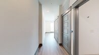 This 640 square foot apartment offers a thoughtful layout that maximizes space efficiency. The single-floor design includes one bedroom, measuring 130 square feet, and one bathroom. The heart of the home is an open-concept kitchen and living room area, promoting a sense of spaciousness and flow.

The interior is characterized by clean lines and a modern aesthetic. Light wood flooring runs throughout, creating a warm and inviting atmosphere. The walls are painted in a crisp white, further enhancing the sense of openness and reflecting natural light.

Recessed lighting in the ceiling provides even illumination, while the inclusion of a sliding door, likely leading to the bedroom or closet, adds a contemporary touch and space-saving functionality. The baseboards are painted in a contrasting gray, adding a subtle design element that ties the space together.

Large windows, though not visible in the image, are suggested by the natural light flooding the space. This abundance of natural light not only brightens the interior but also creates a connection with the outside world, making the apartment feel more expansive than its square footage might suggest.

Despite its compact size, the apartment appears to offer ample storage solutions, including a dedicated closet. The thoughtful design ensures that every square foot is utilized effectively, making this space an excellent example of modern, urban living.