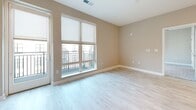 Located at 2555 Riva Rd in Annapolis, MD, this single-floor residence offers a thoughtfully designed layout with modern finishes throughout. Light wood-look flooring extends across the main living areas, creating a bright and cohesive aesthetic. The open-concept kitchen is a standout feature, showcasing gray shaker-style cabinetry, a herringbone-patterned tile backsplash, stainless steel appliances including a French door refrigerator, microwave, range, and dishwasher, plus a central island that provides additional prep and dining space. Recessed lighting illuminates the kitchen with a clean, contemporary feel. The living area benefits from large sliding glass doors that open to a private balcony, inviting natural light and outdoor views into the space. The bedroom features plush carpeting, a generous window with a roller shade, and direct access to a closet and the full bathroom. The bathroom is finished with light wood-look tile flooring, a gray vanity with ample storage, and a full tub-shower combination adorned with elegant marble-style tile surround. Clean white panel doors and neutral warm-toned walls are consistent throughout, contributing to a fresh, modern ambiance suited for comfortable everyday living in the heart of Annapolis.
