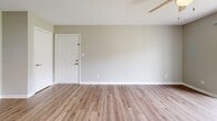 Located in Pensacola, FL, this two-bedroom, two-bathroom single-floor home offers a thoughtfully designed layout with modern updates throughout. The living room features warm wood-look vinyl flooring, neutral toned walls, and a textured ceiling, creating a clean, welcoming atmosphere. Adjacent to the living area, the galley-style kitchen is well-appointed with gray shaker cabinets, white countertops, a tile backsplash, stainless steel appliances including a range, microwave, refrigerator, and dishwasher, and matching vinyl plank flooring that ties the space together seamlessly. A dedicated laundry closet with washer and dryer hookups adds everyday convenience. The primary bedroom is generously sized, featuring plush carpet, a ceiling fan, a natural light window with outdoor views, a walk-in closet with built-in shelving, and a private ensuite bathroom. The ensuite is finished with gray shaker vanity cabinetry, a white countertop, brushed nickel fixtures, and a framed mirror. The second bedroom also features carpet, a ceiling fan, and a bright window. The second bathroom includes a full tub-shower combination with clean white tile surround and vinyl plank flooring. Throughout the home, consistent neutral tones and updated finishes create a cohesive, move-in ready aesthetic.
