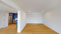 Located at 1500 Main St in Lynchburg, Virginia, this single-floor unit showcases a clean, modern design highlighted by light hardwood flooring and crisp white walls that carry consistently throughout every room. The open layout creates a seamless flow between living and kitchen areas, with the kitchen serving as a striking focal point. Bold, high-gloss royal blue cabinetry lines the walls from floor to ceiling, complemented by white countertops, gold-toned hardware, stainless steel appliances, and an eye-catching geometric patterned tile backsplash. A dedicated range hood adds a sleek, functional touch. The living and bedroom spaces are bright and airy, benefiting from large windows that invite natural light and offer outdoor views of the surrounding neighborhood. Recessed lighting throughout ensures consistent illumination in every room. The bedrooms feature wall-mounted PTAC units for individual climate control. The bathroom is thoughtfully finished with large-format marble-look tile, a built-in shower niche, blue hexagonal tile accent strip, and chrome fixtures, delivering a spa-like atmosphere. Clean panel doors with matte black hardware complete the refined, contemporary aesthetic of this well-appointed space.