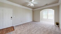Located in Mauldin, South Carolina, this two-bedroom, one-bathroom residence offers a practical and well-organized single-floor layout. The kitchen is equipped with black appliances, including an electric range, microwave, and refrigerator, complemented by light wood cabinetry, granite-style countertops, and warm wood-look flooring that extends into the adjacent areas. A breakfast bar provides a convenient transition between the kitchen and the living space.

The living area is carpeted and features a ceiling fan with a light fixture, along with natural light from windows fitted with blinds. A distinctive arched entryway connects the living space to the rest of the home, adding an architectural detail that enhances the overall flow.

The primary bedroom is generously sized, featuring a tray ceiling with crown molding, a ceiling fan, soft carpeting, and a window that brings in natural light. The second bedroom is similarly appointed with plush carpet and a ceiling fan. A dedicated closet provides useful storage.

The bathroom includes a full soaking tub and shower combo with a curtain rod, wood-look flooring, and a clean, neutral aesthetic consistent with the rest of the home. A hallway connects all rooms efficiently, completing this well-designed and comfortable residence in the Brookwood Point community.