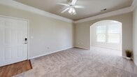Located in Mauldin, South Carolina, this two-bedroom, one-bathroom residence offers a practical and well-organized single-floor layout. The kitchen is equipped with black appliances, including an electric range, microwave, and refrigerator, complemented by light wood cabinetry, granite-style countertops, and warm wood-look flooring that extends into the adjacent areas. A breakfast bar provides a convenient transition between the kitchen and the living space.

The living area is carpeted and features a ceiling fan with a light fixture, along with natural light from windows fitted with blinds. A distinctive arched entryway connects the living space to the rest of the home, adding an architectural detail that enhances the overall flow.

The primary bedroom is generously sized, featuring a tray ceiling with crown molding, a ceiling fan, soft carpeting, and a window that brings in natural light. The second bedroom is similarly appointed with plush carpet and a ceiling fan. A dedicated closet provides useful storage.

The bathroom includes a full soaking tub and shower combo with a curtain rod, wood-look flooring, and a clean, neutral aesthetic consistent with the rest of the home. A hallway connects all rooms efficiently, completing this well-designed and comfortable residence in the Brookwood Point community.