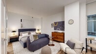 Located at 130 S Juniper Street in Philadelphia's vibrant Center City neighborhood, this one-bedroom, one-bathroom unit offers a thoughtfully designed open-concept layout that maximizes every inch of its intimate footprint. Light-toned hardwood flooring flows throughout, creating a cohesive and airy feel across the living and sleeping areas.

The kitchen is a standout feature, outfitted with two-tone cabinetry — warm wood-grain lower cabinets paired with crisp white uppers — complemented by clean white quartz countertops and a subway tile backsplash. Stainless steel appliances, including a French door refrigerator, electric range with over-the-range microwave, and dishwasher, provide a fully functional cooking space. A small dining area with a round marble-top table tucks neatly beside the kitchen window.

The bedroom is a comfortable retreat, featuring clean white walls, warm ambient lighting from bedside lamps, and room for a full furniture arrangement including a dresser and lounge chair. Tasteful artwork adds character to the space.

The bathroom is finished in a clean, contemporary style with large-format gray floor tiles, crisp white walls, a wood-tone vanity with a light countertop, and well-placed fixtures. The overall design palette throughout the unit is modern and neutral, offering a calm, livable environment in the heart of Philadelphia.