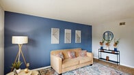 Located at 855 King Arthur Dr in Fayetteville, NC, this two-story, 2-bedroom, 2-bathroom home offers a well-organized layout spread across two floors. The main level features a welcoming living room with plush carpeting, a bold blue accent wall, a textured ceiling, and a window that lets in natural light. Adjacent to it, the dining room continues the blue accent wall theme, complemented by hardwood-style flooring, a ceiling fan, and vertical blinds leading to natural light. The two spaces connect seamlessly, creating a cohesive and functional living area. A dedicated laundry room on this level includes a full-size washer and dryer with overhead shelving for added storage. Upstairs, both bedrooms feature ceiling fans, soft carpeting, and the signature blue accent walls that tie the home's design together cohesively. The primary bedroom is generously sized with a closet and ample room to furnish comfortably. The two bathrooms include a tub-shower combo with warm wood cabinetry and hardwood-style flooring, providing a clean and functional finish. Throughout the home, the consistent use of cool-toned accent walls, ceiling fans, and a mix of carpet and wood-style flooring creates a cohesive, modern aesthetic.