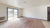 Located at 242 Amber Trl in Sun Prairie, Wisconsin, this single-floor, one-bedroom, one-bathroom unit offers a straightforward and functional layout well-suited for everyday living. The living area is carpeted and bright, featuring a ceiling fan, baseboard heating, and a sliding glass door that floods the space with natural light while providing direct outdoor access and views of the surrounding neighborhood. A wall-mounted air conditioning unit adds year-round climate control convenience.

The galley-style kitchen is efficiently designed with light wood cabinetry, laminate countertops, tile flooring, a double-basin sink, and white appliances including a refrigerator, electric range, and dishwasher. Ample upper and lower cabinet storage makes the most of the kitchen's compact footprint.

The bedroom is a comfortable, carpeted room with a window fitted with blinds for natural light and privacy, along with a closet for storage. The bathroom features a tiled tub-shower combination, a wood-vanity with under-sink storage, and a distinctive mosaic tile floor in soft blue tones, lending a clean, classic character to the space.

Throughout the unit, neutral wall tones and consistent carpeting create a cohesive, move-in-ready atmosphere suitable for those seeking a manageable, no-fuss living space in Sun Prairie.