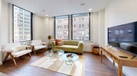Located in the heart of downtown Tulsa, this thoughtfully designed one-bedroom, one-bathroom unit offers a refined urban living experience. Rich hardwood flooring runs throughout the space, tying together each room with a warm, cohesive aesthetic.

The living room is a standout feature, lined with large floor-to-ceiling windows that flood the space with natural light and frame striking views of Tulsa's surrounding cityscape. The open layout connects seamlessly to the kitchen, which is well-appointed with taupe shaker-style cabinetry, a herringbone tile backsplash, sleek quartz countertops, stainless steel appliances, and a large central island illuminated by modern loop pendant lighting — ideal for both cooking and casual dining.

The bedroom is a calm retreat, featuring a ceiling fan, recessed lighting, and multiple windows that bring in additional natural light and urban views. A dedicated closet provides practical storage.

The bathroom is finished with clean, contemporary materials, including large-format marble-look tile, a herringbone accent wall, and a glass-enclosed walk-in shower, creating a spa-like atmosphere. This well-planned unit combines modern finishes with a prime downtown Tulsa address.