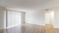 Located at 2390 S Quebec St in Denver, Colorado, this one-bedroom, one-bathroom residence offers a thoughtfully designed single-floor layout with a clean, modern aesthetic throughout. Light-toned luxury vinyl plank flooring runs continuously across the living spaces, complemented by crisp white baseboards and neutral walls that create a bright, cohesive feel.

The living room is generously proportioned and features large sliding glass doors dressed with vertical blinds, allowing abundant natural light to fill the space. A textured ceiling and ceiling fan add functional character to the room. The layout connects seamlessly to a hallway that leads to the remaining areas of the home.

The galley-style kitchen is well-equipped with white shaker cabinetry featuring matte black hardware, marble-look quartz countertops, a stainless steel sink, and stainless steel appliances including a refrigerator and range. A skylight-style overhead fixture keeps the kitchen bright and functional.

The bedroom is a comfortable, well-lit space with a window overlooking greenery and includes a dedicated closet for ample storage. The bathroom is finished with classic white subway tile surrounding a full soaking tub and shower, accented by chrome fixtures for a timeless, clean look.

A hallway connects all rooms efficiently, and a dedicated closet provides additional storage. The overall design is clean, modern, and move-in ready.