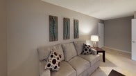 The Rosebud is a thoughtfully designed single-story unit offering one bedroom and one bathroom across a practical, cohesive floor plan. The living room serves as the heart of the space, finished with plush carpeting and warm neutral-toned walls. A sliding glass door floods the room with natural light while providing direct access to a private outdoor area with views of surrounding greenery, creating an inviting indoor-outdoor connection.

The kitchen features rich, wood-grained cabinetry paired with white appliances, including a range and refrigerator, set against light tile flooring. Ample upper and lower cabinet storage is complemented by generous counter space, and a window above the counter brings in additional natural light.

The bedroom is a calm retreat, carpeted and finished with the same warm neutral palette seen throughout the unit. The textured ceiling adds visual character, and the room comfortably accommodates a queen-sized bed alongside additional furniture.

The bathroom is clean and efficiently laid out, featuring a combined tub and shower with a curtain rod, a vanity with a wood-grained cabinet base, light tile flooring, and crisp white walls, providing a functional and tidy space. Throughout the unit, a consistent neutral color scheme creates a cohesive and welcoming atmosphere.