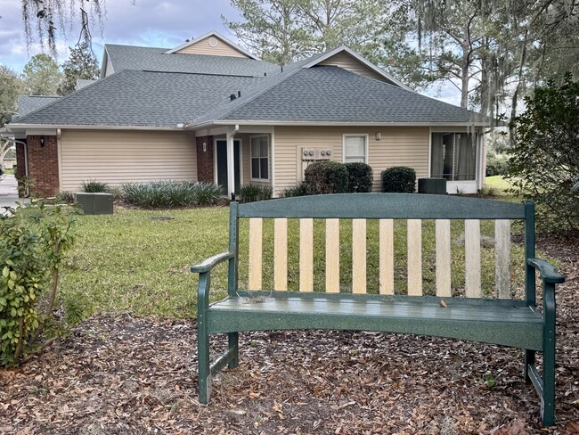 Quintessential bench nestled between pink flowering azalea bushes. - 13200 W Newberry Rd