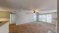 This single-story, one-bedroom, one-bathroom residence offers a practical and comfortable layout designed to maximize everyday living. The spacious living room serves as the heart of the home, featuring warm carpeted flooring, a textured ceiling, and a ceiling fan with integrated lighting. A classic wood-burning fireplace with a white mantel and built-in shelving on either side adds a charming focal point to the room. Large windows with blinds allow natural light to fill the space, and a door provides direct outdoor access.

The galley-style kitchen is efficiently arranged with white cabinetry lining both walls, ample counter space, tile flooring, and a full suite of appliances including an electric range, over-the-range microwave, refrigerator, and dishwasher. A single-basin sink with a window view completes the functional workspace.

The bedroom is generously sized, featuring soft carpet, dual windows that bring in natural light, a ceiling fan, and a closet for storage. The full bathroom includes a single-sink vanity with a large mirror, a tub-shower combination with white tile surround, and tile flooring, offering a clean and functional design throughout.