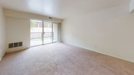 Located at 3400 Eastern Blvd in York, Pennsylvania, this single-floor residential unit offers a straightforward and functional layout designed for comfortable everyday living. The living area is finished with wall-to-wall carpet and filled with natural light through large sliding glass doors that open to a private balcony, offering outdoor views of the surrounding greenery. The open feel of the living space is enhanced by clean white walls and a seamless flow toward the kitchen. The galley-style kitchen is efficiently designed with dark cabinetry lining both sides, light countertops, wood-look luxury vinyl plank flooring, and a full suite of appliances including a gas range, refrigerator, and dishwasher. A stainless steel sink adds a practical touch. The bedroom is generously proportioned, featuring soft carpeting, a large window that allows ample natural light, and access to a closet. The bathroom is finished with white tile surrounding a full soaking bathtub, maintaining a clean and classic aesthetic throughout. The overall ambiance of the unit is bright, neutral, and move-in ready, with a simple, functional design that provides a comfortable living environment in a convenient York location.