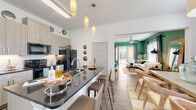 This thoughtfully designed multi-story space spans three floors and showcases a cohesive blend of modern finishes and bold, expressive design choices. The entryway sets a welcoming tone with crisp white walls, wood-look flooring, and curated artwork that hints at the personality carried throughout the home.

The open-concept kitchen is a standout feature, equipped with light wood cabinetry, a striking dark granite waterfall island with bar seating, a white subway tile backsplash, and black stainless steel appliances. Pendant lighting overhead adds warmth and visual interest. The kitchen flows seamlessly into the living area, which is anchored by vibrant green accent walls and a sliding glass door that opens to a private balcony with outdoor views.

The dining area is defined by dramatic dark walls, generous windows admitting abundant natural light, and ample space for a full dining set. Each bedroom carries its own distinct character — one features deep teal walls and dual windows flanking a statement mirror, while another boasts soaring ceilings with a warm rose accent wall.

Bathrooms are finished with marble-look tile flooring, granite-topped vanities, and white cabinetry, offering a clean, polished aesthetic throughout this richly styled multi-floor residence.