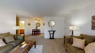 Located at 6840 Schroeder Rd in Madison, WI, this single-floor residence offers a well-organized and functional layout designed for comfortable everyday living. The living room is generously proportioned, featuring wall-to-wall carpeting, neutral tones, and a large sliding glass door dressed with vertical blinds and sheer curtains that invite natural light. The open flow from the living area leads into a defined dining space, complete with a ceiling fan and direct adjacency to the kitchen, making it ideal for both casual meals and entertaining. The kitchen features warm oak cabinetry, light countertops, and wood-style flooring, providing a practical and inviting space for cooking. A dedicated dining area sits just off the kitchen, offering a seamless connection between the two spaces. The bedroom is a comfortable retreat with carpeted flooring, a window with blinds and sheer curtains for natural light control, and ample space for furnishings. The full bathroom includes a wide vanity with a large mirror, oak cabinetry, and a shower-tub combination, finished in neutral tones for a clean, classic look. Throughout the unit, the consistent use of soft carpeting, neutral walls, and warm wood accents creates a cohesive and welcoming ambiance.