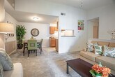 Located at 1741 Lacrosse Dr in Virginia Beach, VA, this single-floor residence offers a well-organized layout with multiple living areas connected through a series of defined spaces. The 3D floor plan reveals a thoughtfully arranged floor plan with distinct bedroom wings, a central living area, and interior staircase access to additional areas.

The living room serves as a central gathering space, highlighted by a corner fireplace with a white mantel and a sliding glass door that opens to an outdoor patio, allowing natural light to fill the room. The carpeted floor and vaulted ceiling contribute to an open, comfortable atmosphere.

The galley-style kitchen features warm honey-toned cabinetry lining both walls, granite-look countertops, a double sink, and white appliances including a range, refrigerator, and dishwasher. Tile flooring and ample upper and lower cabinet storage make this a highly functional cooking space.

The primary bedroom is carpeted and generously sized, with a direct view into an en-suite bathroom featuring a single vanity with dark granite-style countertops, warm wood cabinetry, and a tub/shower combination. A second full bathroom mirrors this design. Additional bedrooms are carpeted and receive natural light through windows, offering comfortable and versatile living spaces.