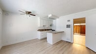 Located at 10339 Zelzah Ave in the Porter Ranch neighborhood of Los Angeles, CA, this single-floor 2-bedroom, 1-kitchen unit offers a functional and well-appointed layout. Light wood laminate flooring runs throughout, lending a clean, cohesive aesthetic to the entire space.

The kitchen is a standout feature, designed in a galley style with crisp white shaker cabinetry, granite-style countertops, a stainless steel double sink, and a gas range. A peninsula with matching countertops extends into the living area, providing additional prep space and a natural boundary between the kitchen and the main living area. A ceiling fan overhead adds comfort to the open shared space.

The living area is bright and airy, benefiting from a window with blinds and a wall-mounted air conditioning unit that ensures year-round comfort. A textured ceiling adds character throughout the common areas.

The primary bedroom is generously sized, offering a sliding glass door that opens to a private outdoor area enclosed by a warm wood fence — a practical and inviting feature. A second bedroom provides additional flexibility for guests, a home office, or other uses. Both rooms carry the same light flooring and neutral white walls, creating a calm and versatile atmosphere throughout this efficiently designed Los Angeles residence.