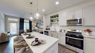 Located in Johns Creek, GA, this thoughtfully designed 2-bedroom, 3-bathroom single-story home offers a seamless blend of modern finishes and functional living spaces. The open-concept kitchen is a standout feature, boasting shaker-style cabinetry, granite countertops, a subway tile backsplash, stainless steel appliances including a gas range and microwave, open shelving, and a large center island with pendant lighting — perfect for both cooking and casual dining. Dark hardwood-style flooring anchors the kitchen and flows into the adjacent living and dining areas. The dining space offers an intimate setting, while the living room provides a comfortable retreat with neutral tones and ample room to relax. The primary bedroom features large windows that invite natural light and outdoor views, a ceiling fan, and plush carpet. The second bedroom includes generous closet storage with bifold doors. The bathrooms are well-finished with granite vanity tops, tile flooring, and clean, contemporary fixtures — including a spacious shared bath with a dual-sink vanity. A hallway and dedicated closet round out the efficient, well-connected floor plan, making this home a polished and practical living space.