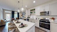 Located in Johns Creek, GA, this thoughtfully designed 2-bedroom, 3-bathroom single-story home offers a seamless blend of modern finishes and functional living spaces. The open-concept kitchen is a standout feature, boasting shaker-style cabinetry, granite countertops, a subway tile backsplash, stainless steel appliances including a gas range and microwave, open shelving, and a large center island with pendant lighting — perfect for both cooking and casual dining. Dark hardwood-style flooring anchors the kitchen and flows into the adjacent living and dining areas. The dining space offers an intimate setting, while the living room provides a comfortable retreat with neutral tones and ample room to relax. The primary bedroom features large windows that invite natural light and outdoor views, a ceiling fan, and plush carpet. The second bedroom includes generous closet storage with bifold doors. The bathrooms are well-finished with granite vanity tops, tile flooring, and clean, contemporary fixtures — including a spacious shared bath with a dual-sink vanity. A hallway and dedicated closet round out the efficient, well-connected floor plan, making this home a polished and practical living space.
