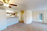 Located at 7901 W Mansfield Pkwy in Lakewood, Colorado, this single-story, one-bedroom, one-bathroom unit offers a well-organized and functional layout across a comfortable footprint. The open living area is carpeted and filled with natural light from large windows fitted with vertical blinds, and includes a ceiling fan overhead. A sliding glass door provides direct access to a private outdoor area, enhancing the sense of openness. The pass-through kitchen features wood-trimmed cabinetry, open shelving, a full-size refrigerator, electric range, built-in microwave, and a double sink, with durable wood-look flooring throughout. A breakfast bar counter separates the kitchen from the living space. The bedroom is a well-proportioned, carpeted room with a large window overlooking the exterior. It connects to a generously sized walk-in closet outfitted with built-in shelving and a hanging rod, offering ample storage. The bathroom includes a single-sink vanity with wood-trimmed cabinetry, a wall mirror with strip lighting, and a full tub-shower combo with tiled surround. An in-unit laundry area and a connecting hallway complete the layout, making this a fully equipped, self-contained residence.
