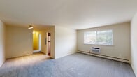 Located at 1917 Oregon Pike in Lancaster, PA, this single-floor unit offers a functional and well-organized layout across its living spaces. The open living area is finished with plush wall-to-wall carpeting and neutral tones, creating a clean, versatile backdrop. A large window allows ample natural light to fill the room while offering views of the surrounding greenery. Baseboard heating and a wall-mounted air conditioning unit ensure year-round comfort throughout the space.

The kitchen stands out as a modern highlight, featuring dark espresso-toned cabinetry with sleek hardware, light countertops, and a classic white subway tile backsplash. Stainless steel appliances — including a gas range, over-the-range microwave, and refrigerator — complete the contemporary look.

The bedroom areas are carpeted and well-lit, each equipped with windows fitted with blinds, baseboard heating, and wall A/C units. The rooms offer generous proportions suitable for various furniture arrangements.

The bathroom is cleanly appointed with white subway tile wainscoting, a pedestal sink, a mirrored medicine cabinet, and hardwood-style flooring, lending a timeless and tidy aesthetic. Overall, the space presents a practical and comfortable living environment in a convenient Lancaster location.