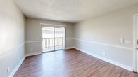 Located at 2320 S Conway Rd in Orlando, FL, this one-bedroom, one-bathroom residence offers a well-planned single-floor layout designed for comfortable everyday living. Warm wood-style flooring flows throughout the unit, complementing the neutral, light gray walls and clean white trim found in every room.

The combined kitchen and living area forms the heart of the space. The kitchen features dark espresso cabinetry, granite-style countertops, a peninsula breakfast bar, a tile backsplash, black appliances including a refrigerator and range, and track lighting overhead. The living area is open and airy, benefiting from a ceiling fan and a sliding glass door that opens to a private balcony, allowing natural light to fill the room.

The bedroom is a comfortable, well-proportioned retreat with a large window that brings in natural light and views of the surrounding area. A dedicated closet provides convenient built-in storage. The bathroom is finished with a clean, white tiled tub-and-shower combination with chrome fixtures.

Throughout the unit, textured ceilings, consistent flooring, and a neutral color palette create a cohesive and functional living environment suited for those seeking a practical and well-located home in Orlando.