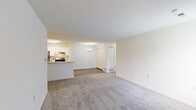 This well-appointed 3-bedroom, 2-bathroom single-floor residence offers a thoughtfully designed layout that maximizes comfort and functionality. The open-concept living and dining area greets you upon entry, featuring plush wall-to-wall carpeting, neutral cream-toned walls, and a small chandelier accent light that adds a touch of elegance. The space flows seamlessly into the kitchen, which is equipped with stainless steel appliances including a gas range and full-size refrigerator, crisp white cabinetry, a stone-look countertop, and a peninsula with a double sink — ideal for both cooking and casual dining.

Each of the three bedrooms is finished with soft carpeting and features windows with vertical blinds that allow for natural light and outdoor views. The spacious primary bedroom offers a comfortable and private retreat. The two bathrooms are clean and modern, with one featuring wood-look tile flooring, a white vanity with under-cabinet storage, and stylish brushed nickel light fixtures.

A dedicated in-unit laundry area with a washer and dryer hookup and overhead shelving adds everyday convenience. A hallway, closet, and staircase complete the layout, ensuring ample storage and easy circulation throughout this bright, move-in-ready home.