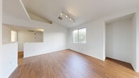 Located at 10115 Jeffreys St in Las Vegas, NV, this well-designed one-bedroom, one-bathroom unit offers a thoughtful layout across a single floor. The open-concept living, dining, and kitchen area forms the heart of the home, featuring warm wood-look flooring and crisp white walls that create a bright, clean aesthetic. Track lighting overhead adds a modern touch, while a large window invites natural light and outdoor views into the living space. Large sliding windows along one wall further enhance the sense of openness and provide neighborhood views.

The kitchen is efficiently arranged with warm wood cabinetry, a gas range, built-in microwave, dishwasher, and a full-size refrigerator, all centered around an L-shaped counter with a double sink. A pass-through connects the kitchen to the living area, making the space feel cohesive and communicative.

The bedroom is a comfortable retreat, distinguished by a charming bay window configuration that allows abundant natural light and views of the surroundings. Soft carpet underfoot adds warmth. A generously sized walk-in closet with wire shelving provides ample storage. The bathroom features a full tub-shower combo with white tile surround and clean chrome fixtures. A dedicated laundry area and hallway complete the functional layout of this well-appointed Las Vegas home.
