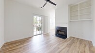 Located at 300 Gatehouse Lane in Odenton, Maryland, this well-appointed three-bedroom, two-bathroom home offers a clean, modern aesthetic across a single level. The open-concept kitchen is a standout feature, boasting crisp white cabinetry with black hardware, quartz countertops, a peninsula with a built-in sink, and a full suite of stainless steel appliances including a range, microwave, dishwasher, and refrigerator. Natural light pours in through multiple windows fitted with blinds, enhancing the bright, airy feel of the space. Light-toned luxury vinyl plank flooring flows throughout the main living areas, while plush carpet adds comfort to the bedrooms. The living room is highlighted by a fireplace, built-in shelving, a ceiling fan, and a sliding glass door that opens to the outdoors. The spacious primary bedroom includes closets and direct access to a private bathroom. Both bathrooms feature white vanities with black hardware and tub-shower combinations. A dedicated laundry room houses a full-size washer and dryer with overhead shelving for additional storage. Two closets provide ample storage throughout the home, completing this well-designed and move-in-ready residence.