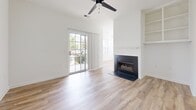 Located at 300 Gatehouse Lane in Odenton, Maryland, this well-appointed three-bedroom, two-bathroom home offers a clean, modern aesthetic across a single level. The open-concept kitchen is a standout feature, boasting crisp white cabinetry with black hardware, quartz countertops, a peninsula with a built-in sink, and a full suite of stainless steel appliances including a range, microwave, dishwasher, and refrigerator. Natural light pours in through multiple windows fitted with blinds, enhancing the bright, airy feel of the space. Light-toned luxury vinyl plank flooring flows throughout the main living areas, while plush carpet adds comfort to the bedrooms. The living room is highlighted by a fireplace, built-in shelving, a ceiling fan, and a sliding glass door that opens to the outdoors. The spacious primary bedroom includes closets and direct access to a private bathroom. Both bathrooms feature white vanities with black hardware and tub-shower combinations. A dedicated laundry room houses a full-size washer and dryer with overhead shelving for additional storage. Two closets provide ample storage throughout the home, completing this well-designed and move-in-ready residence.