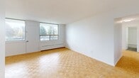 Located at 30 High St E in Mississauga, this 2-bedroom, 1-bathroom unit offers a functional and well-maintained layout across a single floor. Warm parquet flooring runs throughout the living spaces and both bedrooms, lending a classic character to the interior. The living area is bright and airy, benefiting from large windows that frame pleasant green treetop views, with baseboard heating positioned beneath the sills.

The kitchen has been updated with clean white cabinetry, dark countertops, a grey subway tile backsplash, and stainless steel appliances including a range with oven and an over-the-range microwave. Light-toned tile flooring completes the kitchen's fresh, modern aesthetic.

Both bedrooms are comfortably sized, with the primary bedroom offering a generous footprint. Each room features sliding double-door closets for ample storage, white walls, and windows that bring in natural light and treetop scenery. The hallway connects the rooms in an efficient, straightforward layout.

The bathroom is finished with full white subway tile surrounding a soaker tub and shower combination, chrome fixtures, and a clean, timeless look. Overall, the unit presents a bright, neutral palette throughout, making it a practical and move-in ready space in the heart of Mississauga.