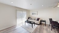 Located in Lynnwood, WA, this well-appointed one-bedroom, one-bathroom unit offers a thoughtfully designed layout across a single floor. The open-concept living and dining area is bathed in natural light, thanks to a large sliding glass door dressed with vertical blinds that leads to the outdoors. Light-toned hardwood-style flooring runs throughout the main living spaces, complementing the neutral warm-beige walls and recessed lighting overhead. A ceiling fan adds both function and style to the combined living and dining area, which comfortably accommodates both a seating area and a dining set. The galley-style kitchen is efficiently laid out with gray shaker cabinetry, quartz-style countertops, a stainless steel sink, and a full suite of appliances including a refrigerator, range, dishwasher, and microwave. The bedroom features plush carpet flooring, a window with blinds for natural light and privacy, and a generously sized closet with built-in shelving. A connecting hallway leads directly to the full bathroom, which is finished with a marble-look vanity countertop, white cabinetry, wood-style flooring, and a shower-tub combination. The overall ambiance is clean, modern, and move-in ready, offering a comfortable and functional living experience.