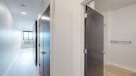 Located at 4555 Minnehaha Ave in Minneapolis, MN, this modern one-bedroom, one-bathroom unit offers a thoughtfully designed layout across a single floor. The open-concept kitchen and living area form the heart of the space, featuring light hardwood flooring, crisp white cabinetry, stainless steel appliances including a range, microwave, and refrigerator, a tile backsplash, and track lighting overhead. The clean lines and neutral palette create a bright, contemporary atmosphere throughout.

The bedroom is a cozy, well-defined room with the same light hardwood flooring and white walls, offering a calm retreat. A sliding dark-paneled door opens to a dedicated closet with built-in shelving and hanging rods, maximizing storage. A second closet provides additional organizational space, a notable convenience for a unit of this size.

The bathroom is accessed through a sleek dark-toned door and includes a vanity, toilet, and towel bar, finished in a clean, minimalist style consistent with the rest of the unit. A private balcony extends the living space outdoors, offering a personal outdoor area. Throughout the unit, modern dark-paneled doors with brushed metal hardware add a stylish contrast to the white walls and light floors, reinforcing the contemporary design aesthetic.