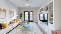 Located at 500 Liberty Ln NW in Fort Walton Beach, FL, this well-appointed 2-bedroom, 2-bathroom single-story residence offers a thoughtfully designed layout with modern finishes throughout. The open-concept kitchen features sleek gray cabinetry, stainless steel appliances including a French door refrigerator, a center island with granite-style countertops and bar seating, and pendant lighting — flowing seamlessly into a combined dining area with an eye-catching textured accent wall and pendant light fixture. The living room continues the refined aesthetic with the same soft, brushstroke-patterned wall treatment and durable wood-look flooring. The spacious primary bedroom is carpeted and bathed in natural light through a large window with a ceiling fan overhead, while the secondary bedroom features a clean, neutral palette with plush carpet and easy hallway access. Each bathroom is finished with granite-topped vanities and gray cabinetry, with a tub-shower combo. Both bedrooms are accompanied by generously sized walk-in closets with wire shelving systems. A dedicated laundry room houses a full-size washer and dryer with overhead shelving for added storage. This residence combines practical functionality with contemporary style in a comfortable single-floor plan.