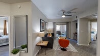 This single-story residence offers a thoughtfully designed layout with modern finishes throughout. The living room serves as the heart of the home, featuring wood-style flooring, a ceiling fan, and a neutral color palette accented by vibrant artwork. A sliding glass door floods the space with natural light and opens directly to a covered patio, where views of mature trees and greenery create a serene outdoor retreat.

The kitchen is well-equipped with white cabinetry, granite-style countertops, stainless steel appliances including a gas range, built-in microwave, and dishwasher, all set against durable wood-style flooring that carries throughout the home.

The primary bedroom is generously proportioned with large windows, a ceiling fan, and direct access to a private patio. It connects to a spacious en-suite bathroom featuring dual vanities with white cabinetry and a dedicated walk-in closet offering ample storage. A second bedroom provides a comfortable and well-lit retreat, complemented by its own ceiling fan and coordinating décor.

A secondary bathroom mirrors the home's clean aesthetic with a white vanity, large mirror, and wood-style flooring. Throughout the residence, the consistent use of light tones, quality finishes, and thoughtful design details contribute to a cohesive and inviting ambiance.